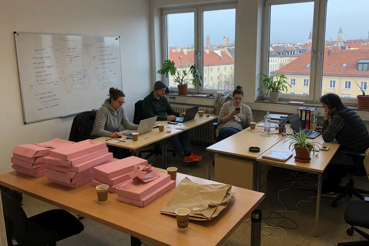 Büro eines kleinen Münchner Teams mit Papierverpackungen auf dem Tisch
